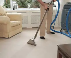 Carpet cleaning professional removing dirt and stains with a hot-water extraction tool in a home, San Diego, CA.