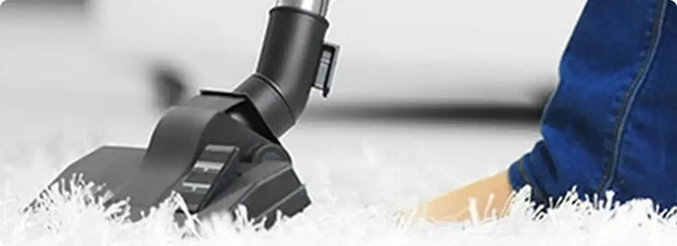 Close-up of a professional vacuuming a white carpet in Coronado.